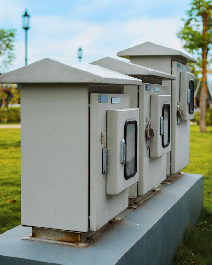 services-04 Close-up of locked electric boxes outdoors, featuring metal cabinets on a platform.
