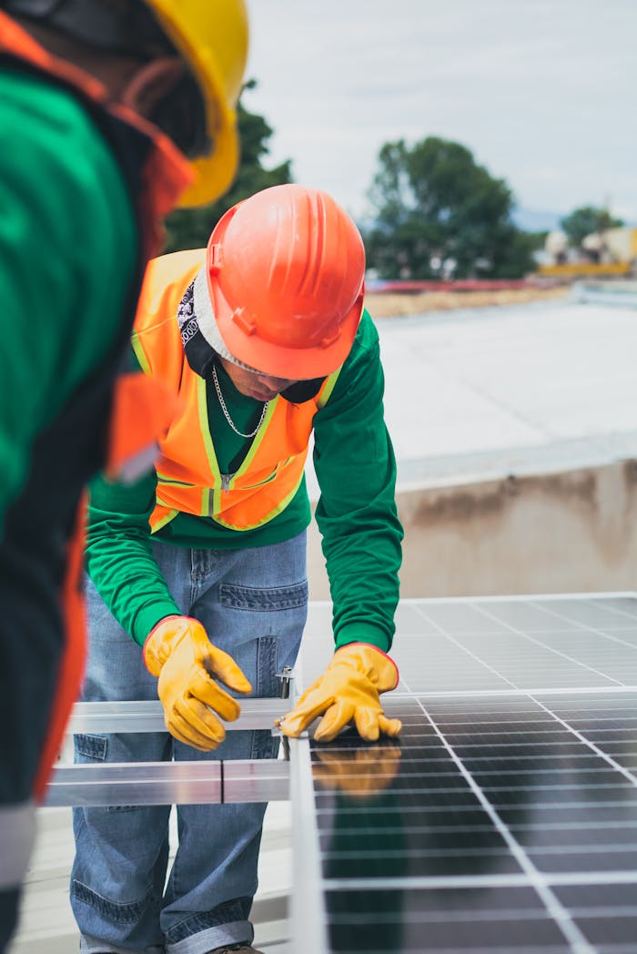 hero-services Worker in safety gear installing solar panels on a rooftop.